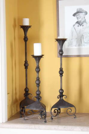 GROUP OF THREE GRADUATED IRON CANDLESTICKS