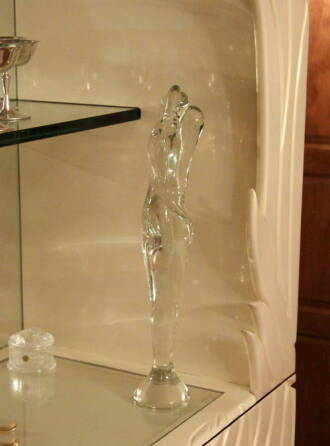 A GLASS FIGURAL SCULPTURE AND A GROUP OF BACCARAT ORESTE CANDLE HOLDERS