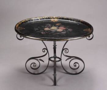 A WROUGHT IRON AND PAPIER MACHE COFFEE TABLE