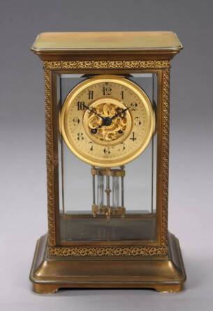 A BRONZE AND BEVELED GLASS TIFFANY MYSTERY CLOCK