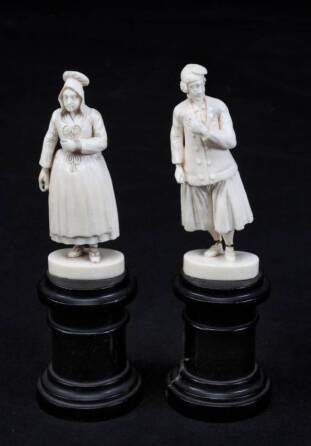 A PAIR OF IVORY FIGURINES OF AN AMERICAN COLONIAL