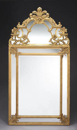 A CARVED AND GILDED ORNATE WALL MIRROR